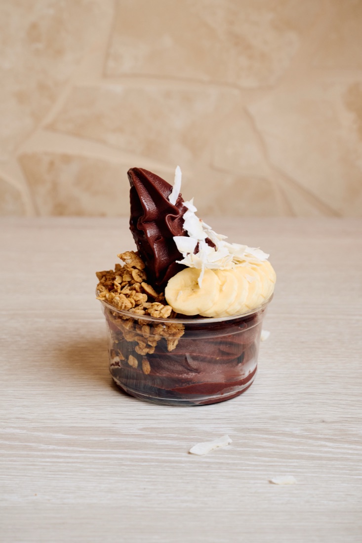 An açai bowl topped with banana, granola and coconut